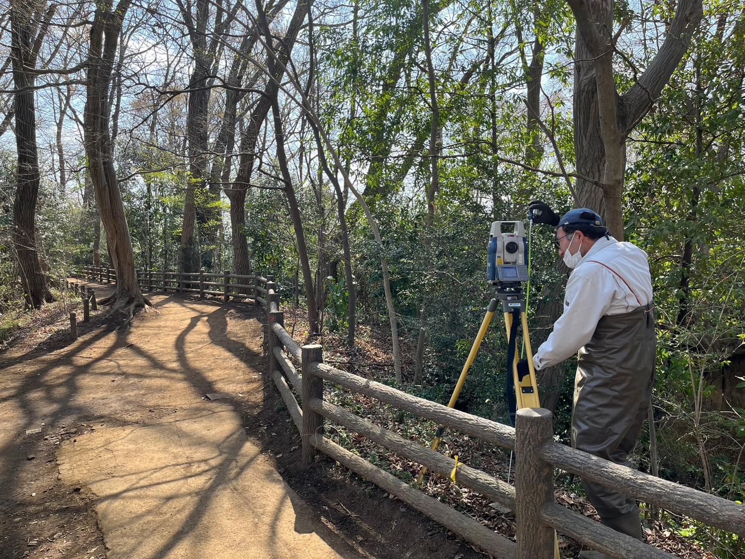 山道で測量をしている社員の風景